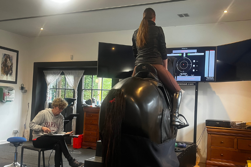 Ruiter op een paardrijsimulator tijdens een workshop over houding en zit